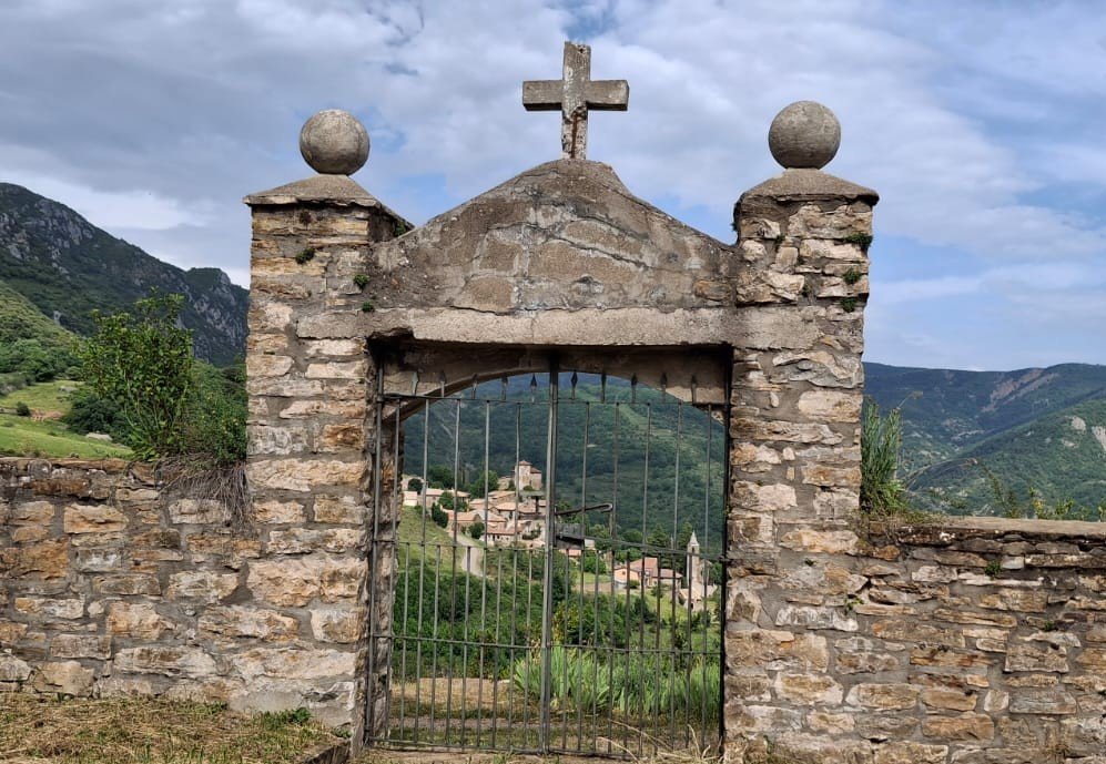 Vistas del pueblo de Calvera en el Valle del Isábena a través del portal de piedra del cementerio