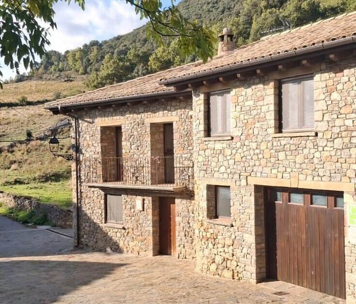 Fachada de piedra tradicional de la casa rural Casa Puixico en el pueblo de Calvera, Valle del Isábena